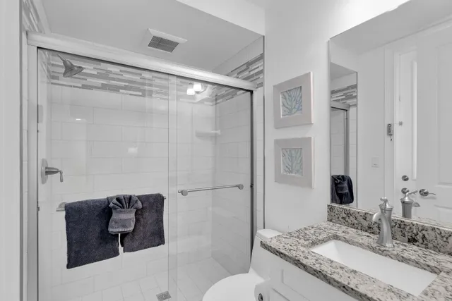 a bedroom with a bed and a lamp on the dresser