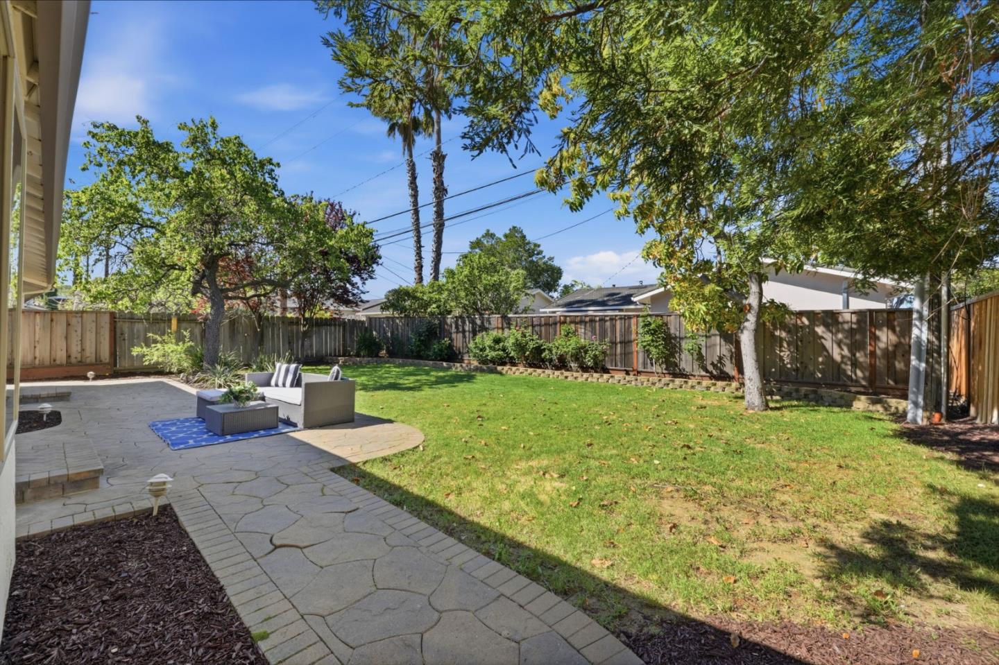 7577 Bollinger Road Cupertino, CA 95014 - Photo 45 of 56 a view of a backyard with table and chairs potted plants and large tree
