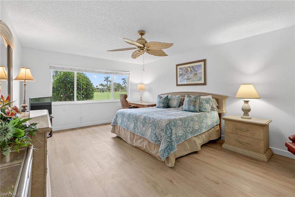 Furnished master bedroom with new floors, and ceiling fan