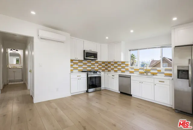 a kitchen with granite countertop white cabinets and white appliances