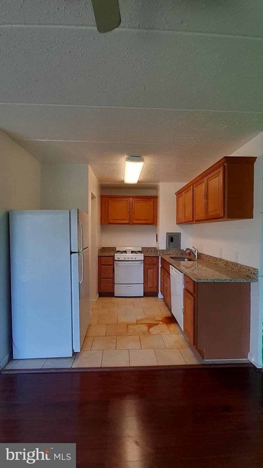 1804 Metzerott Road, Unit 303 Hyattsville, MD 20783 - Photo 6 of 13 a large kitchen with wooden floors and stainless steel appliances