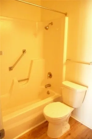 a white toilet sitting next to a bathroom sink and a shower