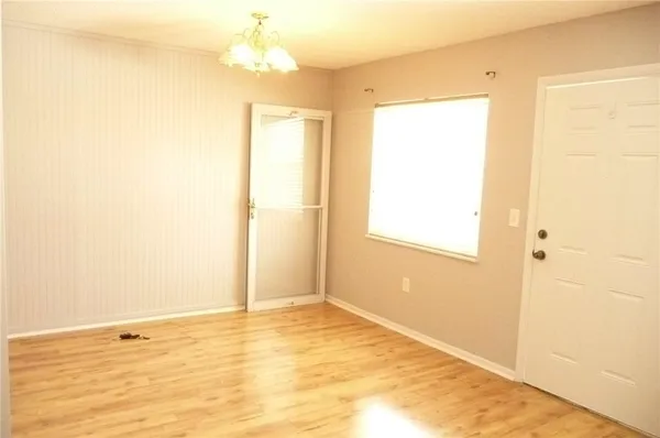 a view of an empty room with window and a ceiling fan