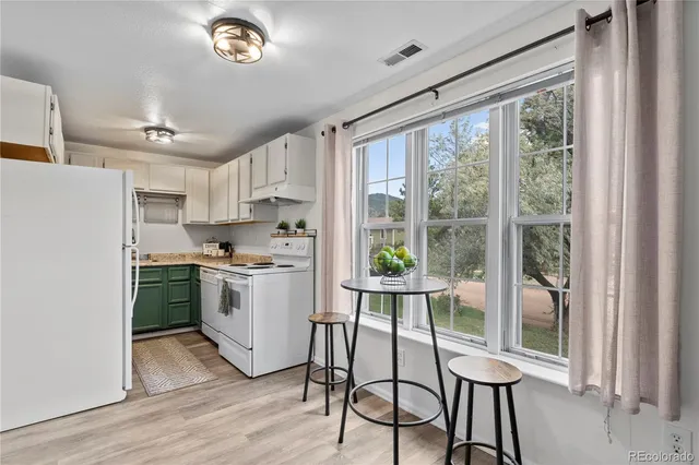 a kitchen with a stove a refrigerator and a view of living room