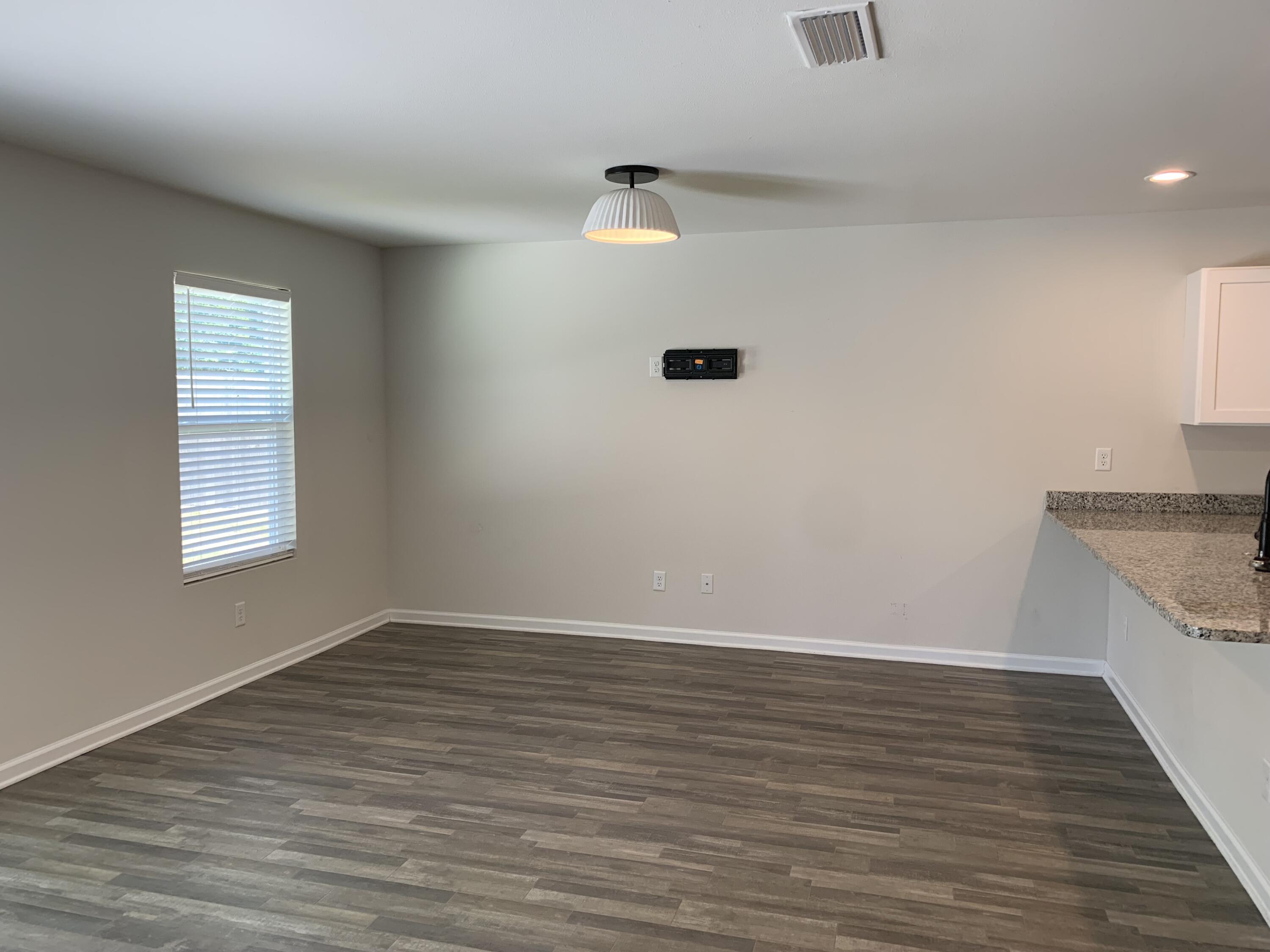 103 Cora Road DeFuniak Springs, FL 32433 - Photo 44 of 72 a view of an empty room with wooden floor and a window