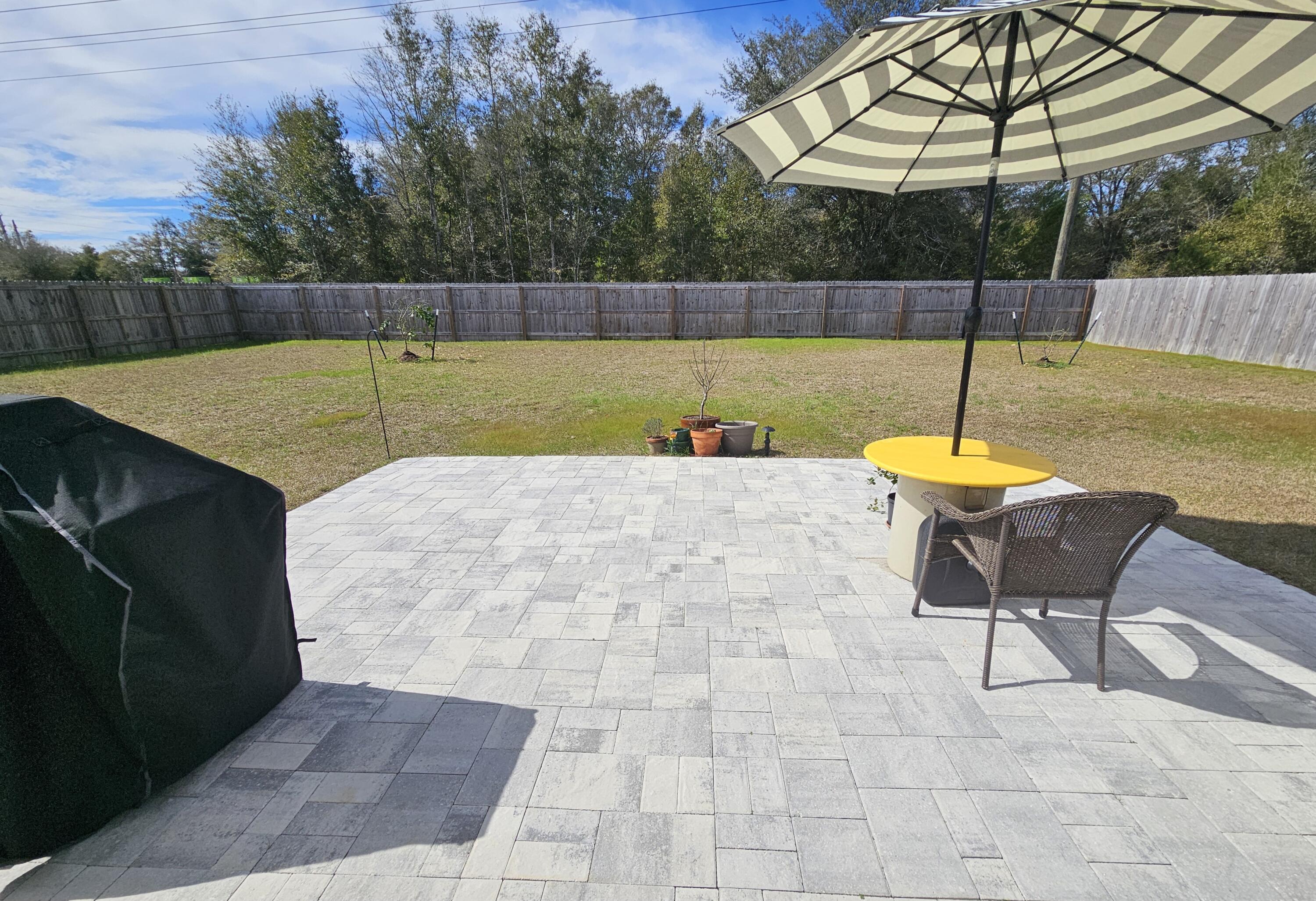103 Cora Road DeFuniak Springs, FL 32433 - Photo 10 of 72 a view of a backyard with a table and chairs under an umbrella