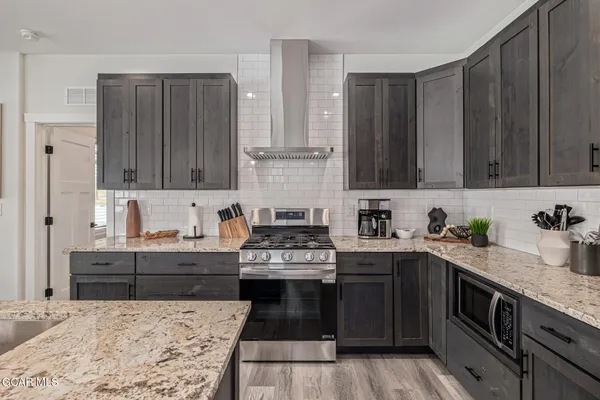 a view of a kitchen counter top a sink and dishwasher with wooden floor