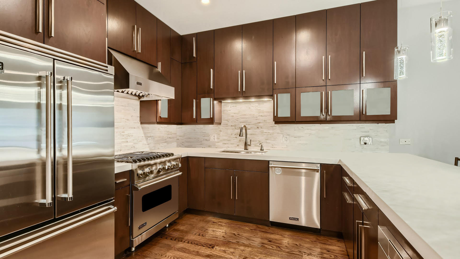 2144 West Rice Street, Unit 1E Chicago, IL 60622 - Photo 5 of 20 a kitchen with a sink stainless steel appliances wooden floor and cabinets