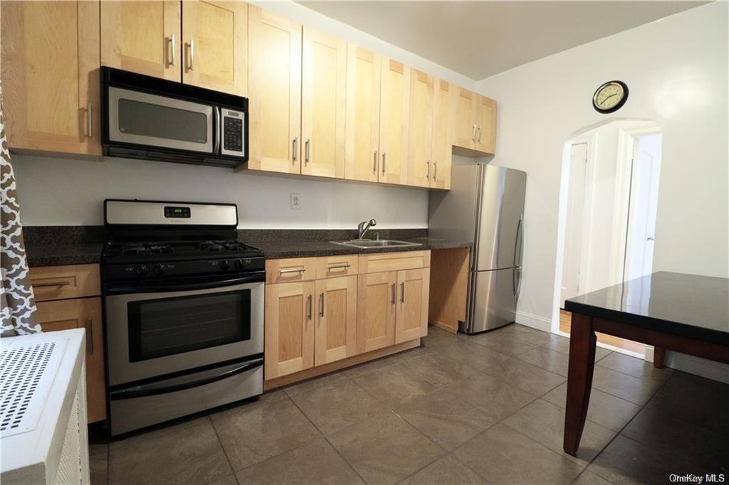 3179 Rochambeau Avenue Bronx, NY 10467 - Photo 4 of 7 Kitchen featuring sink, stainless steel appliances, light brown cabinets, and dark tile patterned flooring