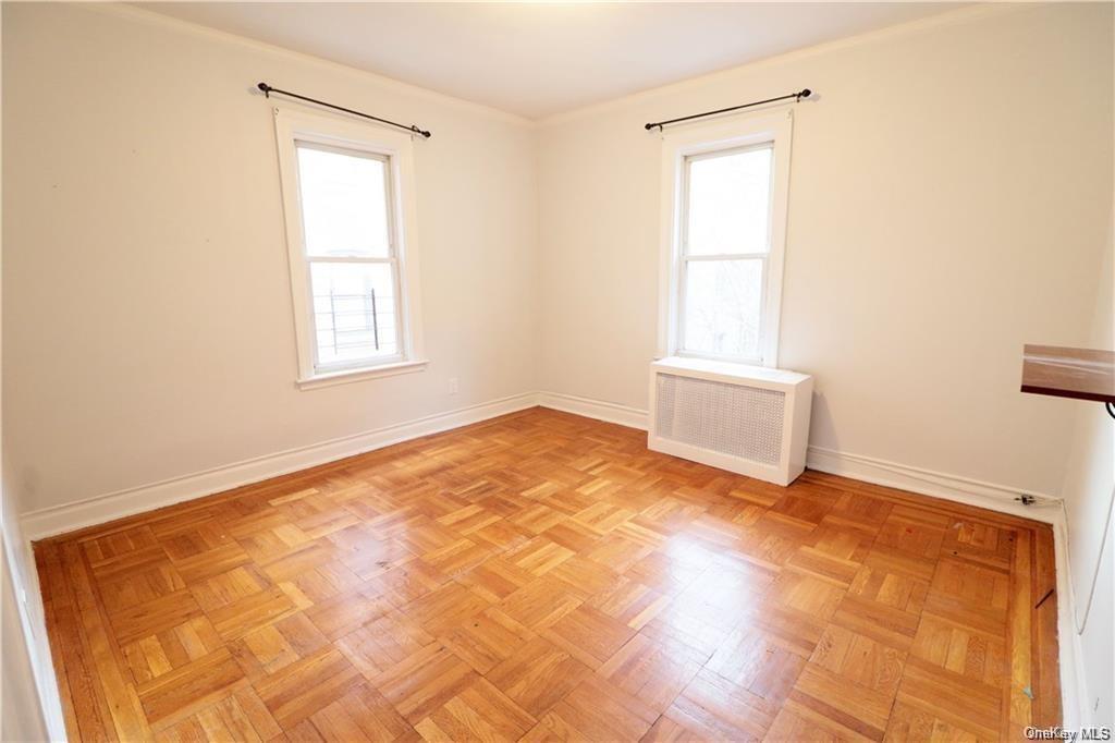 3179 Rochambeau Avenue Bronx, NY 10467 - Photo 5 of 7 Empty room with radiator and light parquet flooring