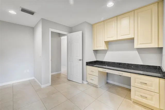 a kitchen with granite countertop white cabinets and stainless steel appliances