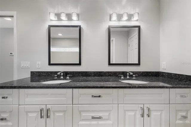 a bathroom with double vanity sinks and a mirror