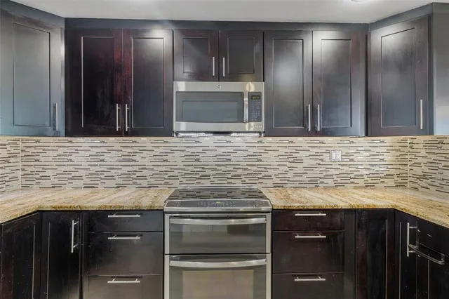 a kitchen with granite countertop stainless steel appliances and cabinets