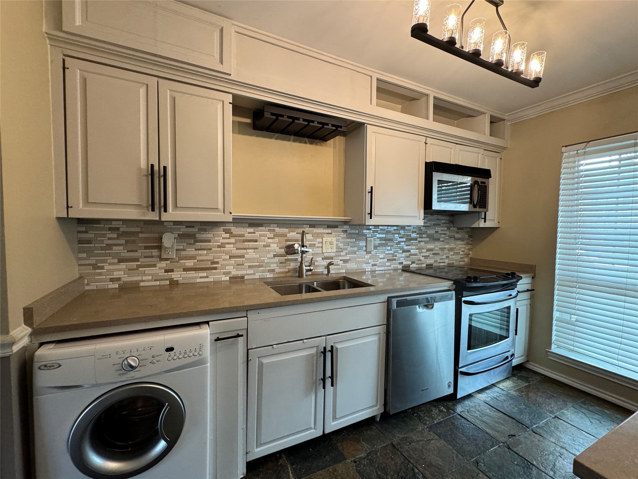 2041 Winrock Boulevard, Unit 157 Houston, TX 77057 - Photo 6 of 25 Quartz countertops and beautifully installed stylish backsplash with additional kitchen storage above the cabinets, plus a built-in wine glass rack for entertaining.