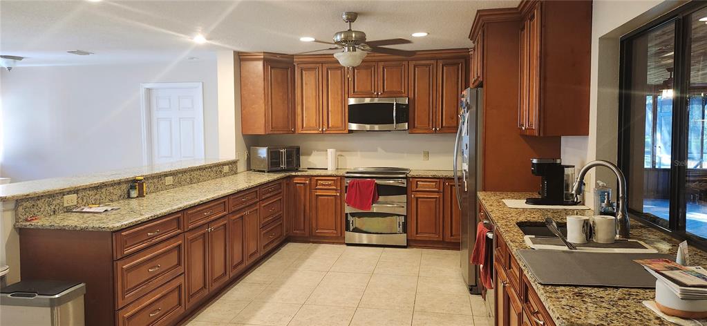 1804 East Wheeler Road Seffner, FL 33584 - Photo 13 of 25 a kitchen with stainless steel appliances granite countertop a sink stove and refrigerator