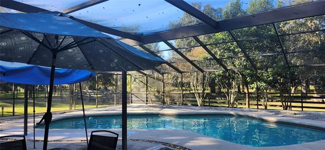 a view of swimming pool with a patio and wooden fence