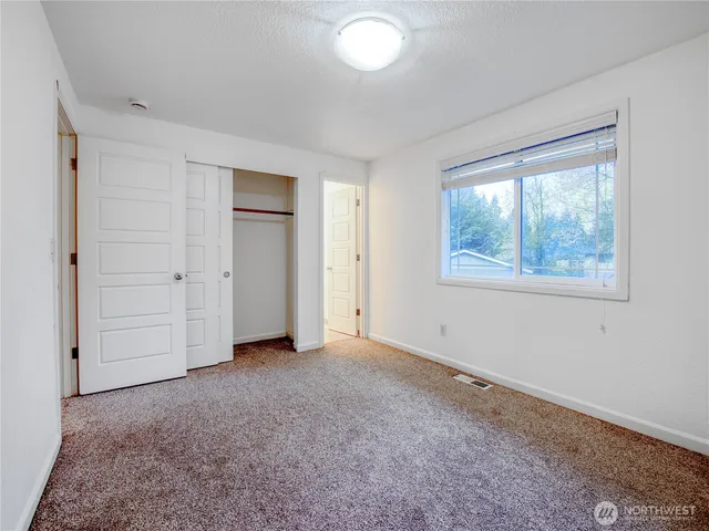 an empty room with windows and closet