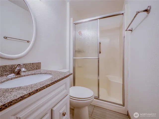 a bathroom with a granite countertop sink toilet and shower