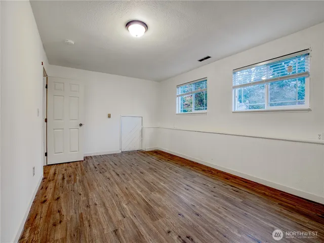 a view of empty room with wooden floor