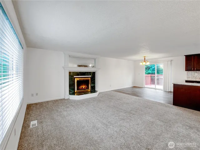 an empty room with windows and fireplace