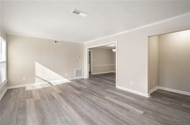 a view of an empty room with wooden floor
