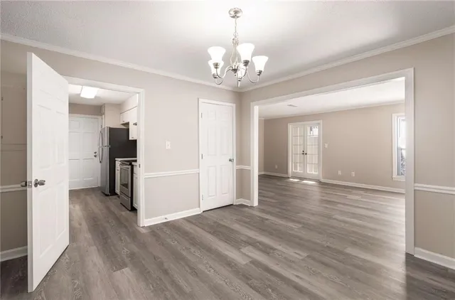 a view of a hallway with wooden floor and a chandelier