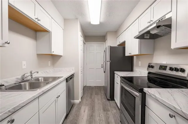 a kitchen with a sink cabinets and stainless steel appliances