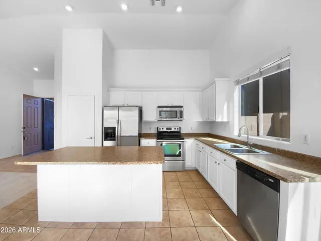 a large kitchen with kitchen island a sink stainless steel appliances and cabinets