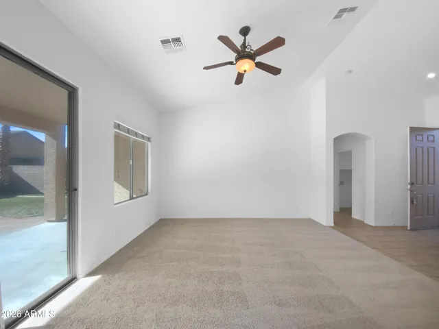 an empty room with closet and a chandelier fan