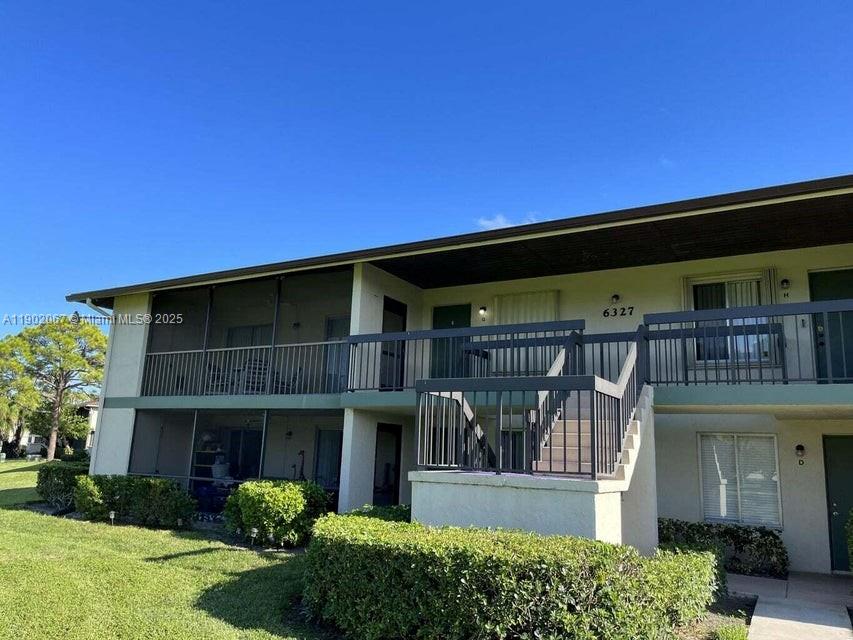 6327 Chasewood Drive, Unit G Jupiter, FL 33458 - Photo 2 of 35 a front view of house and yard with green space