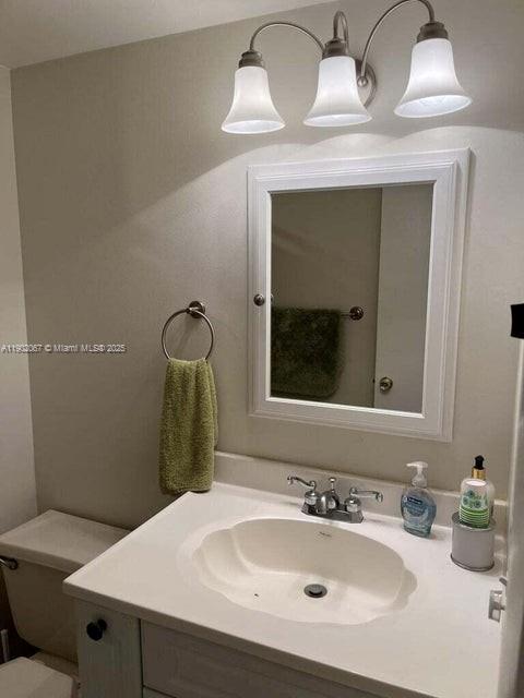 6327 Chasewood Drive, Unit G Jupiter, FL 33458 - Photo 29 of 35 a bathroom with a sink and a mirror