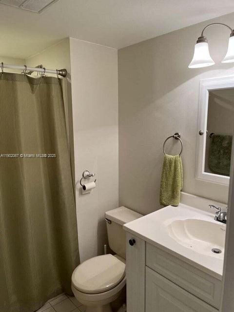 6327 Chasewood Drive, Unit G Jupiter, FL 33458 - Photo 30 of 35 a bathroom with a sink vanity mirror and toilet