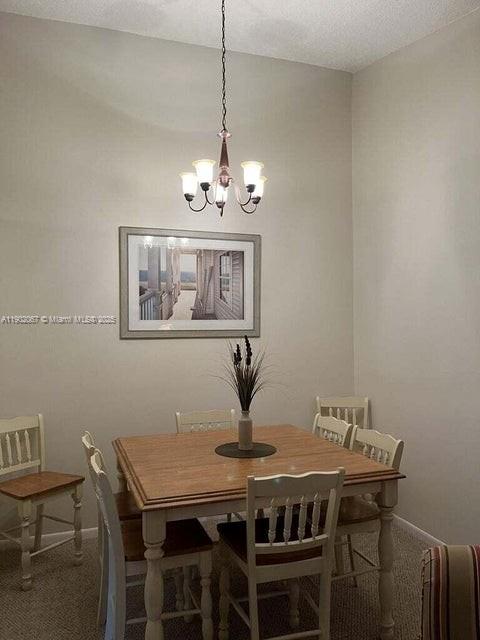6327 Chasewood Drive, Unit G Jupiter, FL 33458 - Photo 7 of 35 a view of a dining room with furniture wooden floor and a chandelier