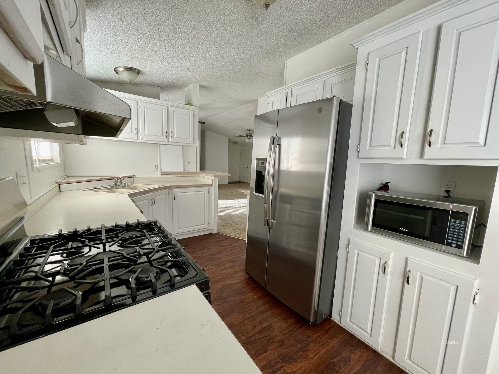 1465 Pony Street Ridgecrest, CA 93555 - Photo 4 of 32 a kitchen with stainless steel appliances a refrigerator a stove and white cabinets