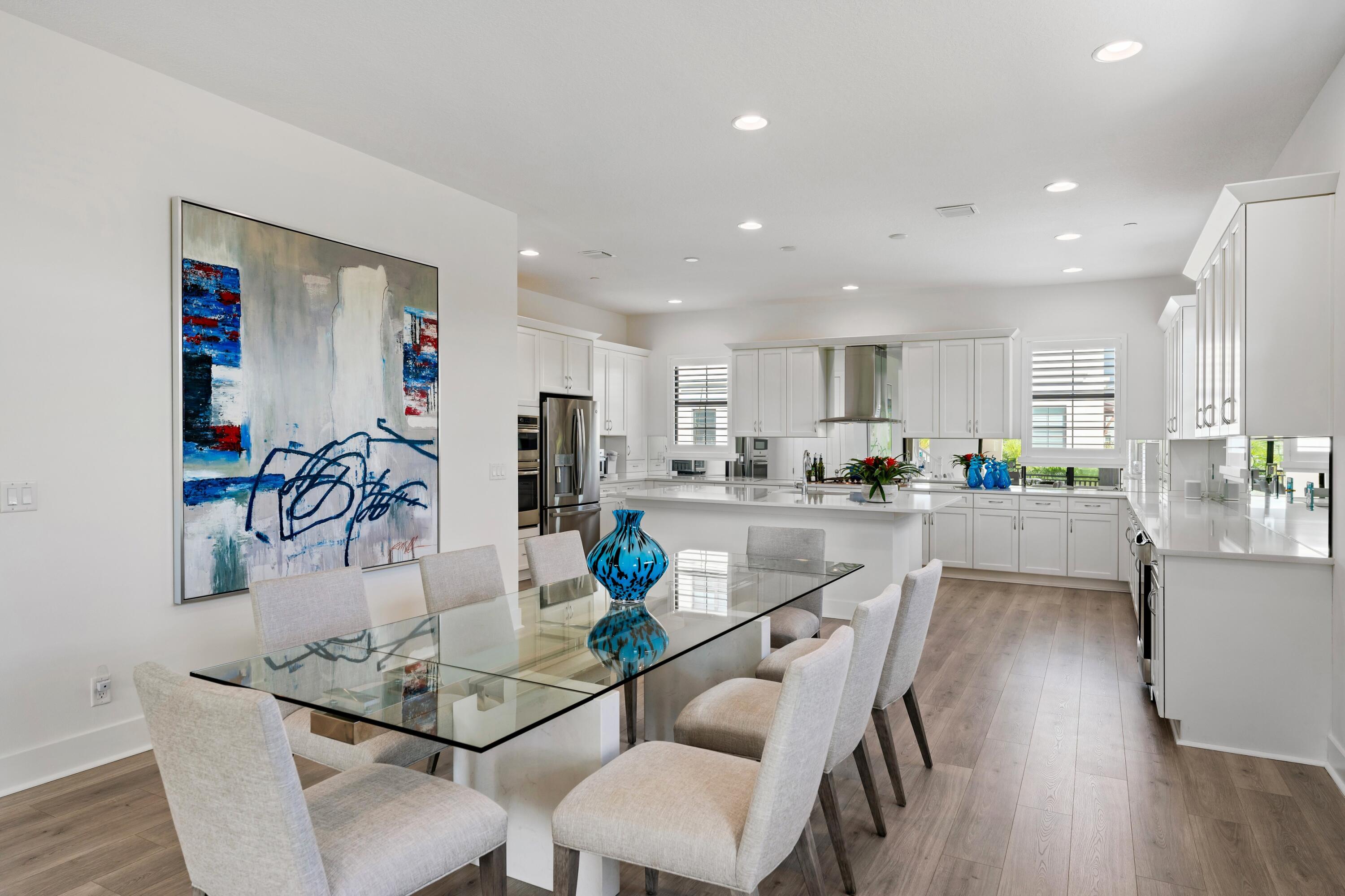 a dining room with stainless steel appliances kitchen island granite countertop a dining table chairs and view kitchen