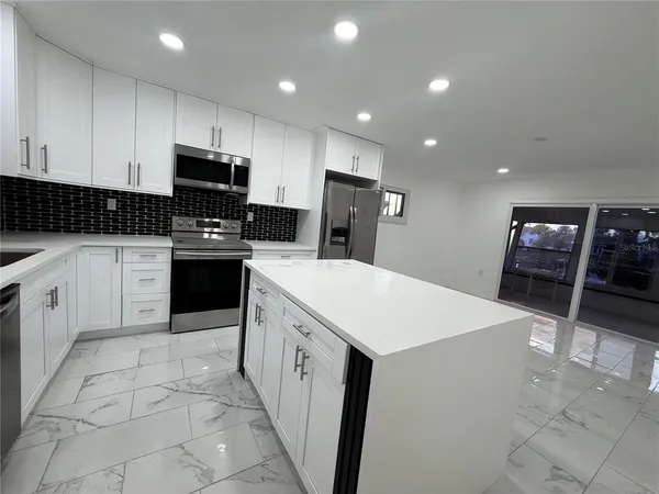 a kitchen with stainless steel appliances a stove sink microwave and cabinets