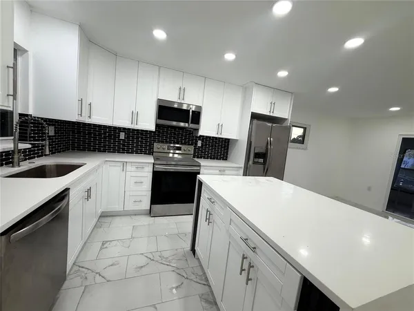 a kitchen with a sink a stove a refrigerator and cabinets