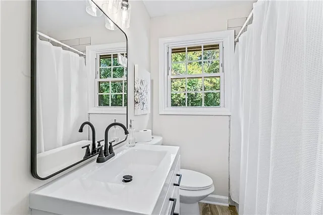 a bathroom with a sink a toilet and a mirror