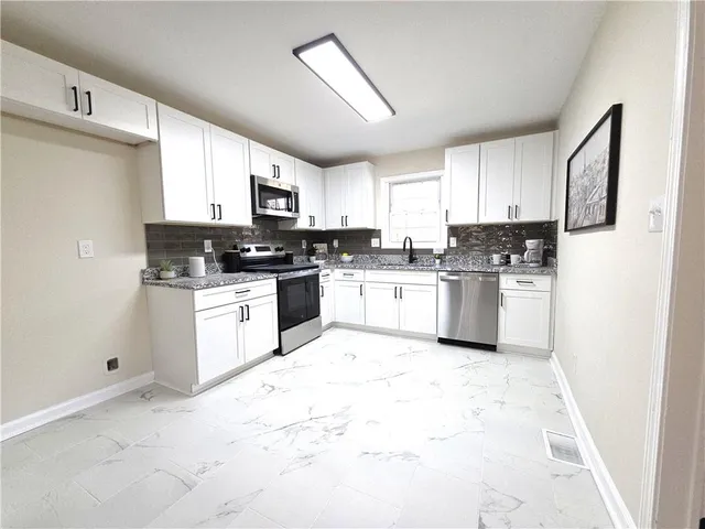 a kitchen with white cabinets and white appliances