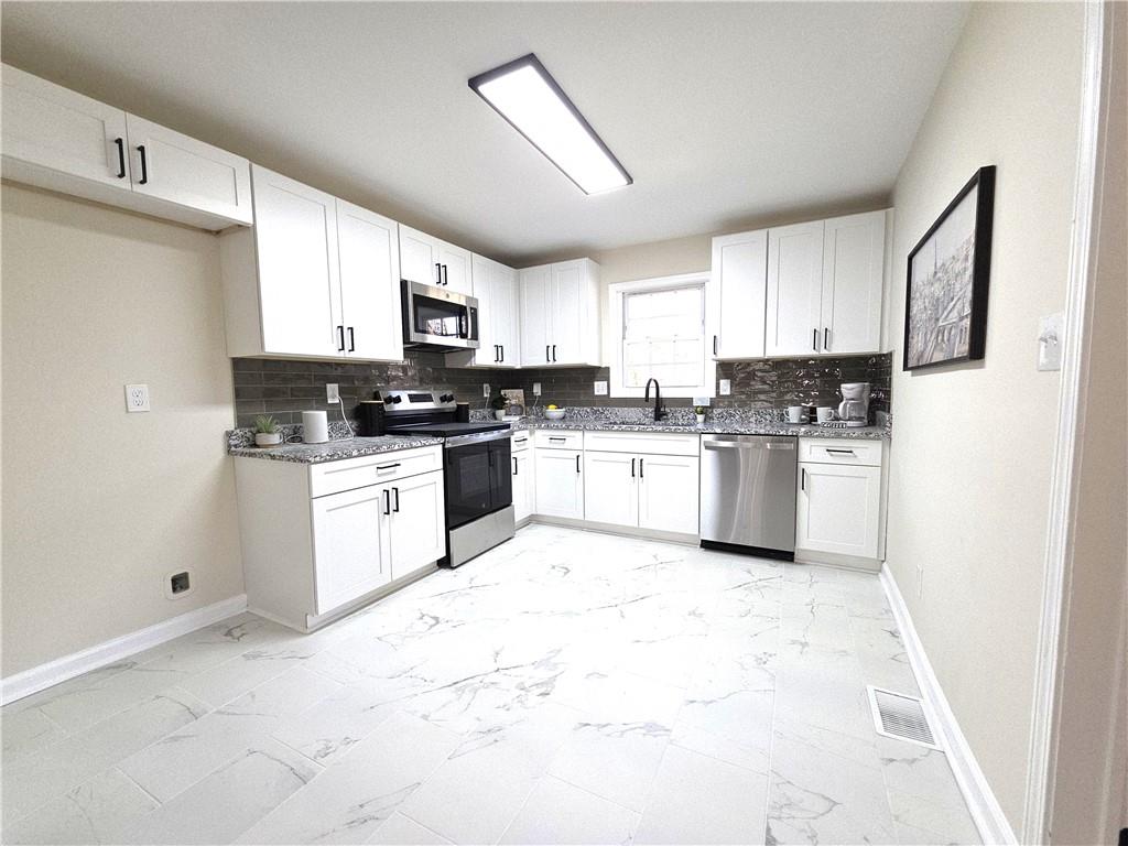 1576 South Gordon Road Southwest Austell, GA 30168 - Photo 2 of 33 a kitchen with white cabinets and white appliances