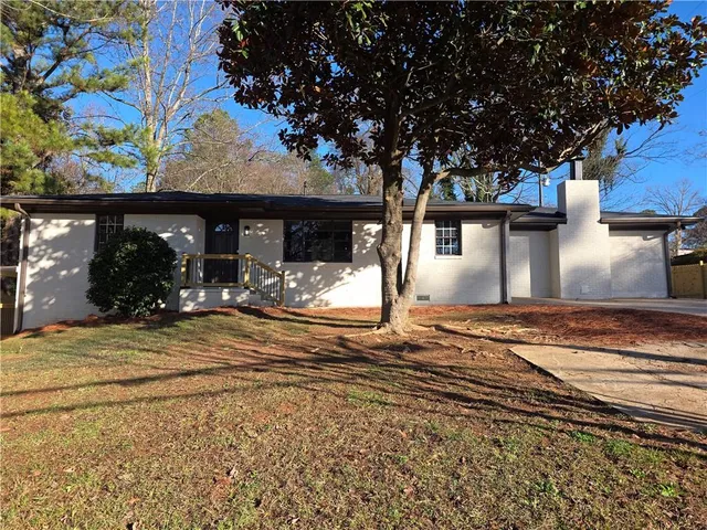 a view of a house with backyard and a tree