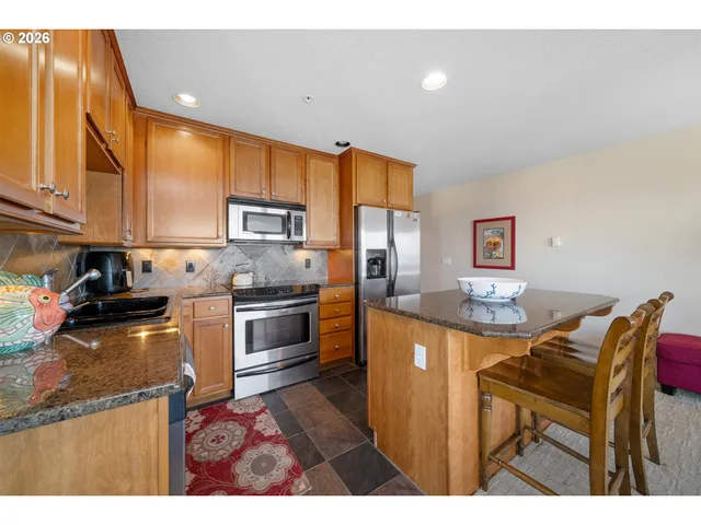 a living room with stainless steel appliances kitchen island granite countertop furniture and a view of kitchen
