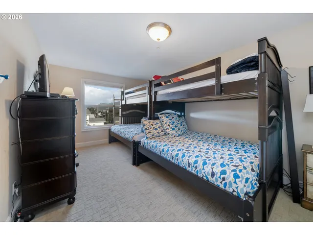 a bedroom with a bed and a tv on the dresser