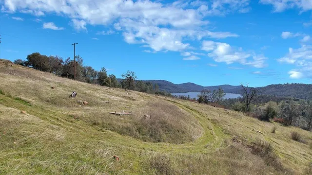 a view of a dry yard with mountains in the background