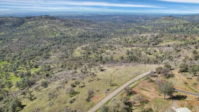a view of a dry yard with wooden floor and fence