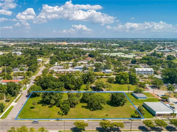 an aerial view of residential houses with outdoor space and ocean view