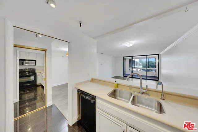 a kitchen that has a sink cabinets counter space and appliances