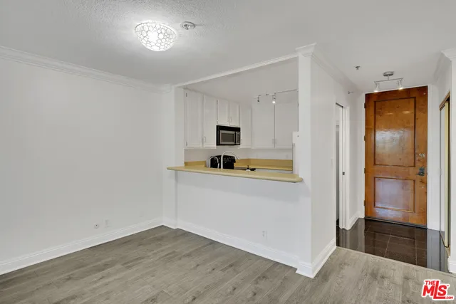 a view of kitchen with a sink refrigerator and wooden floor