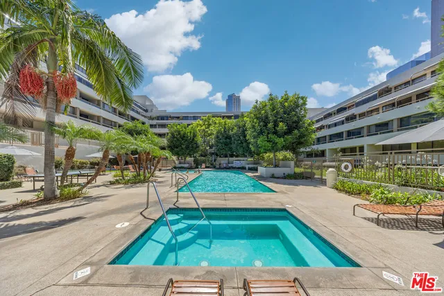 a view of a backyard with couches and swimming pool