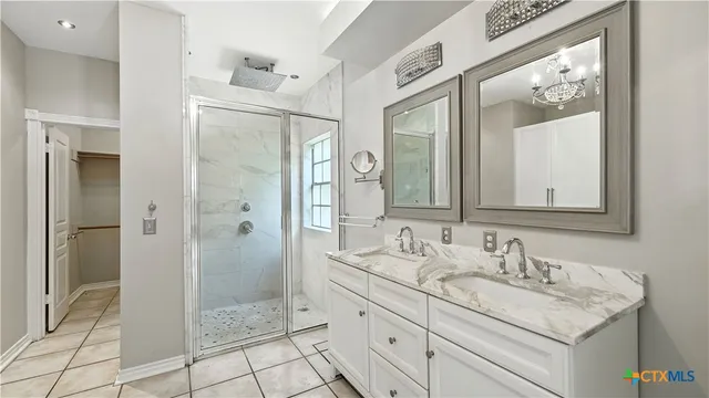 a bathroom with a granite countertop sink mirror and shower
